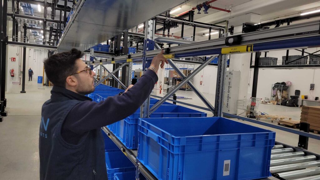 pick to light: operatore che preme la luce per segnalare il prelievo merce