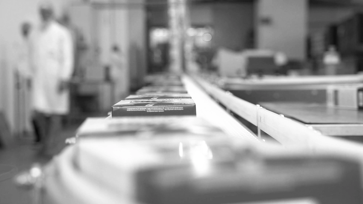 nastro trasportatore porta merce confezionata di Roberto appena uscita dalla produzione, con operai in camicia bianca che controllano il processo