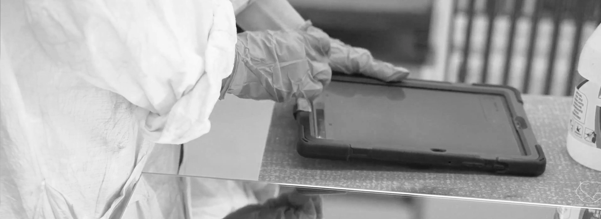 Production operator wearing protective gloves uses MES (Manufacturing Execution System) software in production via a tablet.