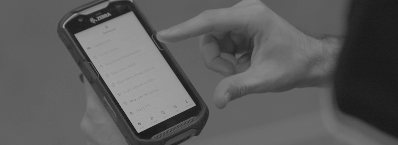 Operatore in magazzino utilizza un terminale mobile con app / software SCES per la gestione della supply chain