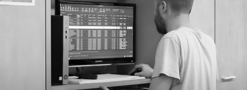 A warehouse operator checks the workstation displaying KPIs from logistics and production software